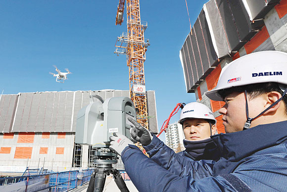 경기 김포에서 건설 중인 e편한세상 ‘김포 로얄하임’ 현장에서 대림산업 직원들이 3D 스캐너와 드론을 활용해 BIM 설계에 필요한 측량자료를 촬영하고 있다. 대림산업 제공