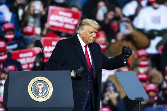 도널드 트럼프 미국 대통령이 31일(현지시간) 펜실베이니아주 몽투르빌에서 열린 유세에서 지지자들을 향해 검은 장갑을 낀 손으로 주먹을 쥐어 보이고 있다.  몽투르빌 게티/AFP 연합뉴스