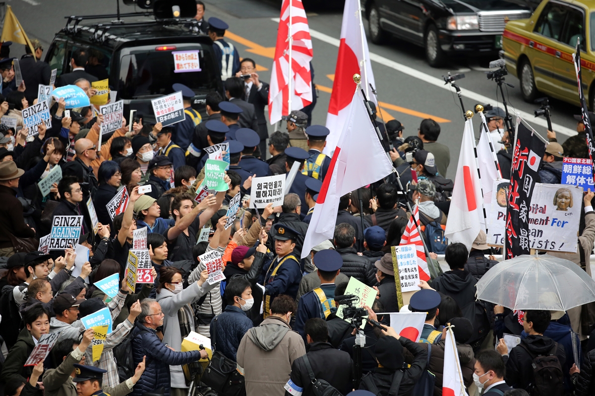 2016년 3월 6일 오후 일본 도쿄도 긴자 거리에서 재일조선학교 보조금 중단 등을 요구하는 시위대(사진 오른쪽)가 행진하는 가운데 이에 반대하는 시민들(왼쪽)이 피켓을 들고 항의하고 있다. 2016.3.6 연합뉴스
