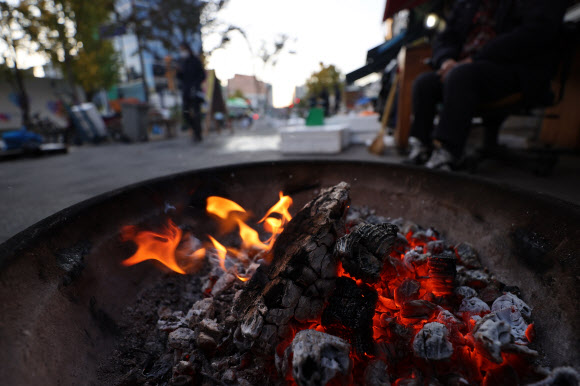 아침 기온이 5도 이하로 추운 날씨를 보인 3일 오전 서울 중구 새벽시장에서 상인들이 불을 쬐고 있다. 2020.11.3  연합뉴스