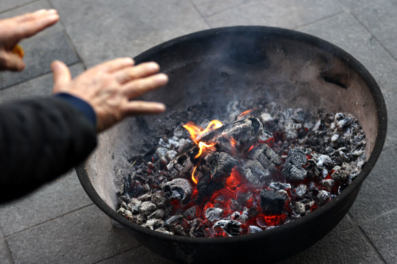 아침 기온이 5도 이하로 추운 날씨를 보인 3일 오전 서울 중구 새벽시장에서 상인들이 불을 쬐고 있다. 2020.11.3  연합뉴스