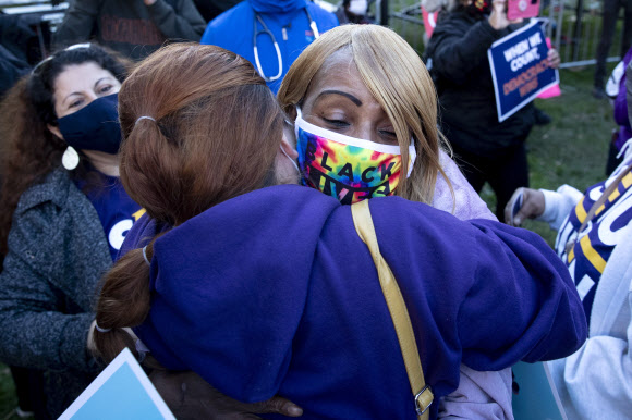 바이든 지지자들이 미국 대선 다음날인 4일(현지시간) 워싱턴DC 백악관 인근 맥퍼슨 광장에서 열린 모임에서 미시간주가 바이든 민주당 후보에게 갈 것이라는 언론 보도가 나오자 포옹하며 기쁨을 나구고 있다. EPA 연합뉴스