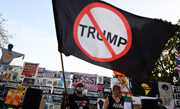 미국의 시위대들이 6일 백악관 근처에서 반 트럼프 깃발을 흔들고 있다. 연합뉴스