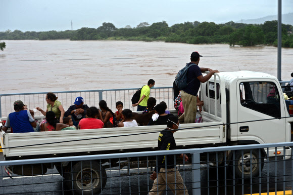 허리케인 에타가 지나간 후로요에서 대피한 주민들이 6일(현지시간) 온두라스 요로부 엘 프로그레소 시에서 트럭을 타고 이동하고 있다. AFP 연합뉴스