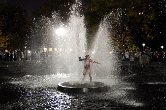 한 남성이 6일(현지시간) 미국 뉴욕에서 열린 선거 결과를 기다리면서 워싱턴 스퀘어 공원의 분수대에서 춤을 추고 있다. AP 연합뉴스