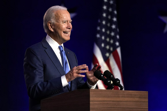 조 바이든 미국 민주당 대선후보가 6일(현지시간) 자택이 있는 델라웨어주 윌밍턴의 체이스센터에서 부통령 러닝메이트인 카멀라 해리스 상원의원과 연단에 올라 대국민 연설을 하고 있다. AP 연합뉴스