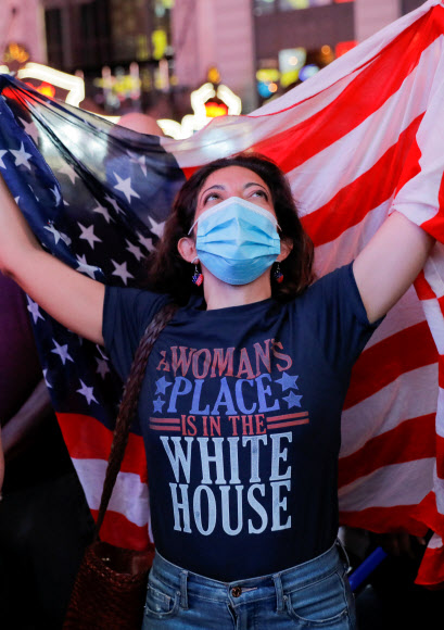 7일(현지시간) 미국 뉴욕 타임스스퀘어에서 한 시민이 조 바이든의 대통령 당선인의 승리 연설을 보고 있다. 로이터 연합뉴스