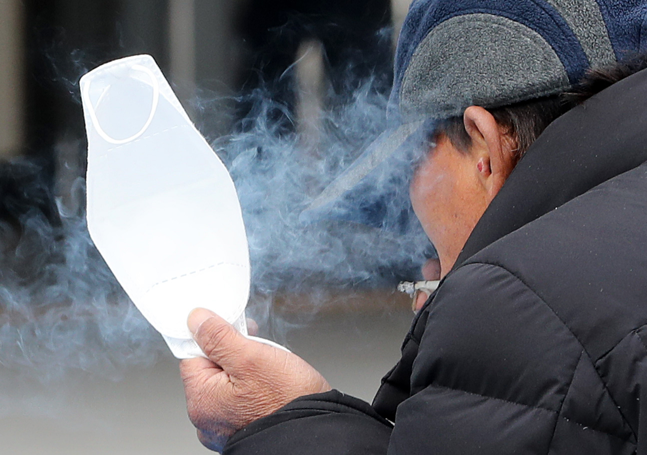 신종 코로나바이러스(코로나19) 국내발생 확진자가 5주 연속 증가추세를 보인 9일 서울역 광장에서 한 시민이 한 손에 마스크를 들고 담배를 피고 있다. 2020.11.9 뉴스1