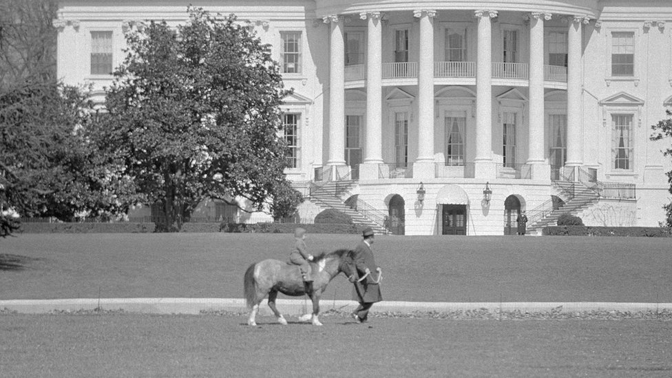 미국 비밀경호국 요원이 1962년 존 F 케네디 전 대통령의 딸 캐롤라인을 반려 말 마카로니 등에 앉힌 채 끌고 있다.캐롤라인은 나중에 주일 미국 대사가 된다. AFP 자료사진