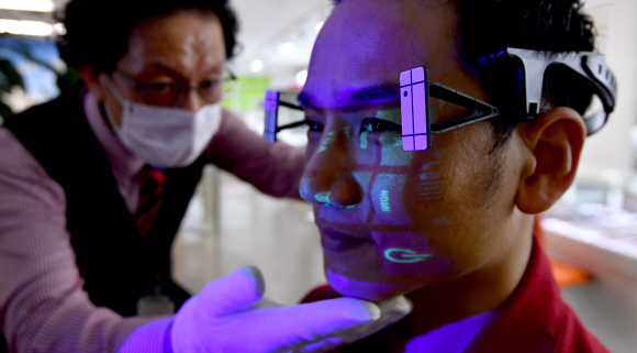 서울의 안경 판매업체 아이닥안경에서 기술자가 맞춤 안경을 제작하기 위해 두상을 3D 입체 스캔하고 있다. 이 작업을 통해 개인의 두상에 맞는 안경 테의 길이, 크기, 코의 높이 등을 측정하고 이 수치를 바탕으로 흘러내림이 없는 꼭 맞는 안경을 제작한다.