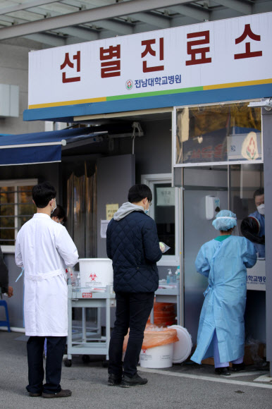 14일 오전 광주 동구 전남대병원 선별진료소에서 의료진이 신종 코로나바이러스 감염증(코로나19) 검사를 받기 위해 줄을 서 있다. 전남대병원 전공의가 전날 밤 코로나19 확진 판정을 받으면서 일부 시설 출입이 통제되고 동료 의료진과 환자 등이 진단 검사를 받고 있다. 2020.11.14  연합뉴스