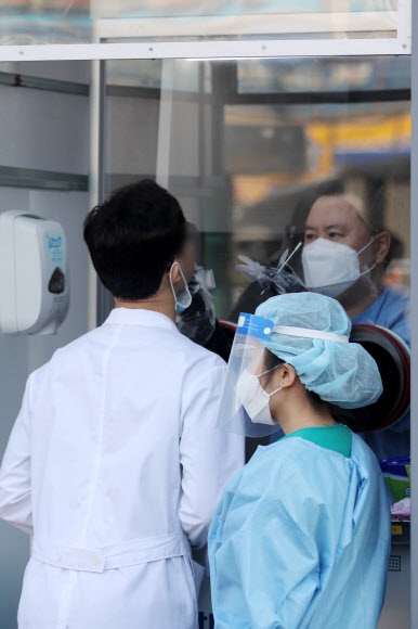 14일 오전 광주 동구 전남대병원 선별진료소에서 의료진이 신종 코로나바이러스 감염증(코로나19) 검사를 받기 위해 문진표를 작성하고 있다. 전남대병원 전공의가 전날 밤 코로나19 확진 판정을 받으면서 일부 시설 출입이 통제되고 동료 의료진과 환자 등이 진단 검사를 받고 있다. 2020.11.14  연합뉴스