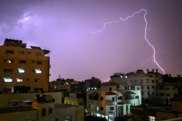 번개가 15일(현지시간) 가자시티에서 폭풍우가 몰아치는 동안 건물 위로 번쩍이고 있다. AFP 연합뉴스