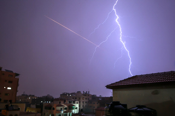 번개가 15일(현지시간) 가자시티에서 폭풍우가 몰아치는 동안 건물 위로 번쩍이고 있다. AFP 연합뉴스