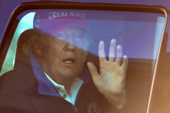 14일(현지시간) 골프장에서 백악관으로 돌아오던 트럼프 대통령이 백악관 인근에 모인 지지자들에게 손을 흔들고 있다. 워싱턴 로이터 연합뉴스