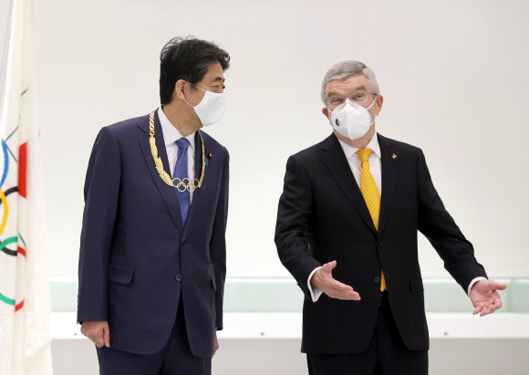 토마스 바흐 국제올림픽위원회(IOC) 위원장이 16일 오후 일본 도쿄 신주쿠 올림픽 박물관에서 아베 신조 전 일본 총리에게 올림픽 훈장을 수여한 뒤 대화를 나누고 있다. 2020.11.16  교도 연합뉴스
