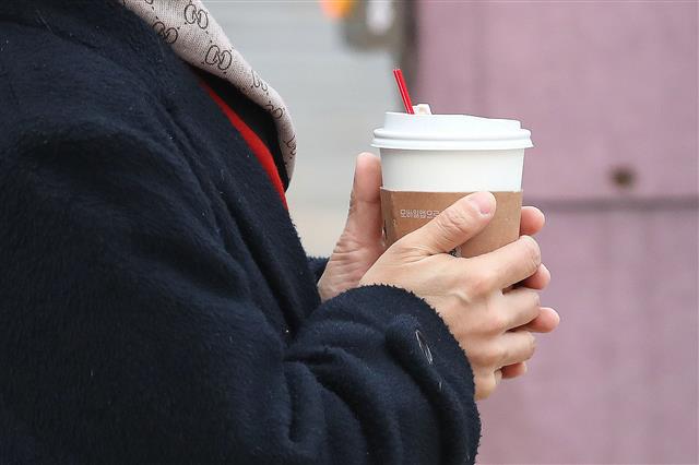 전국 아침 기온이 전날보다 10도 이상 큰 폭으로 떨어진 20일 서울 광화문 광장 인근에서 한 시민들이 따듯한 커피로 손을 녹이고 있다. 기상청은 이날 아침 기온은 -1~11도로 전날의 13~23도 보다 중부지방과 전라도는 15도 이상, 그 밖의 지역은 10도 이상 큰 폭으로 떨어지겠다고 예보했다. 2020.11.20 뉴스1