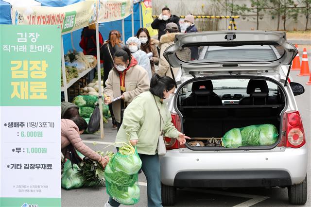 20일 오전 경기도 용인 미르스타디움에서 시민들이 신종 코로나바이러스 감염증(코로나19) 예방을 위해 드라이브 스루 방식으로 김장을 위한 재료들과 김장김치를 구매하고 있다. 2020.11.20 뉴스1