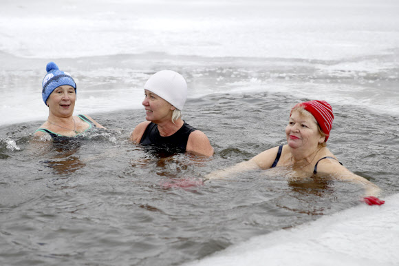 지역 냉수 훈련과 겨울 수영 공동체의 여성들이 21일(현지시간) 러시아 노보시비르스크의 꽁꽁 언 블라이우드세 호수 속에서 휴식을 취하고 있다. 타스 연합뉴스