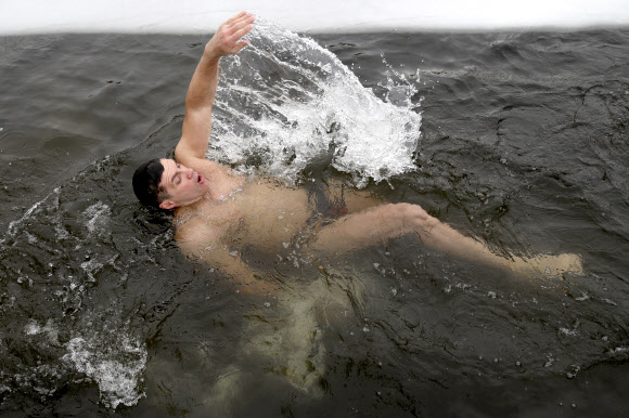 지역 냉수 훈련과 겨울 수영 공동체의 한 남성이 21일(현지시간) 러시아 노보시비르스크의 꽁꽁 언 블라이우드세 호수 속에서 수영을 하고 있다. 타스 연합뉴스