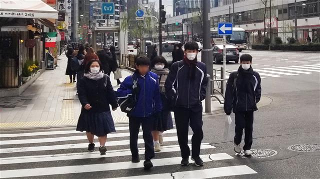학교 수업을 마친 일본 도쿄의 중고생들이 무리를 지어 걸어가고 있다.