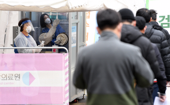 코로나 19 확산세가 이어지고 있는 24일 서울 국립중앙의료원 선별진료소에서 의료진들이 코로나 19 검사를 하고 있다.   이날 국립중앙의료원은 현재 수도권에 남아있는 신종 코로나바이러스 감염증(코로나19) 중환자 병상은 총 25개로, 최근 2주간 환자발생 추이로 봤을 때 1주일 정도면 소진될 가능성이 높다고 밝혔다. 2020.11.24 오장환 기자 5zzang@seoul.co.kr