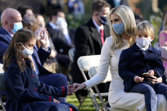 이방카 트럼프 대통령 보좌관이 24일(현지시간) 미국 워싱턴 백악관 로즈 가든에서 추수감사절 전통에 따라 열린 칠면조 사면식에서 아들 테오도르 쿠슈너와 함께 앉아, 딸 아라벨라 쿠슈너(왼쪽)의 손을 잡고 있다. AP 연합뉴스