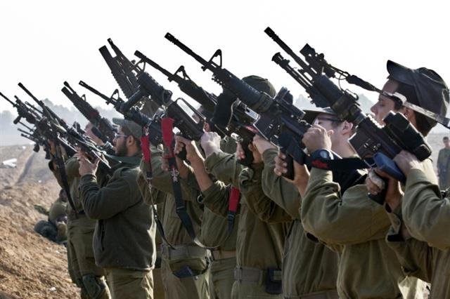 국경지역에서 이스라엘 기갑부대 대원들이 소총을 점검하는 모습. AFP 엽합뉴스