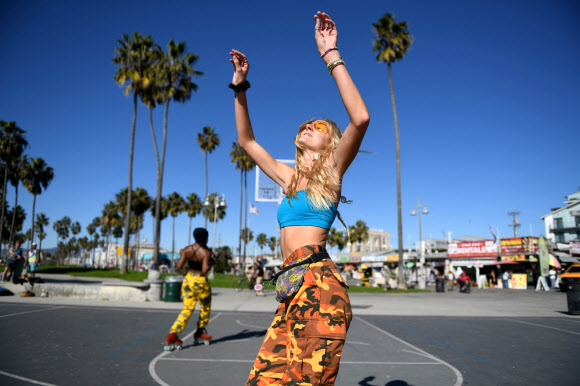 코로나19 확산을 막기 위한 자택 대피령이 내려지기 하루 전인 29일(현지시간) 미국 캘리포니아주 로스앤젤레스의 해변에서 사람들이 롤러블레이드를 타며 여유를 즐기고 있다. 로이터 연합뉴스