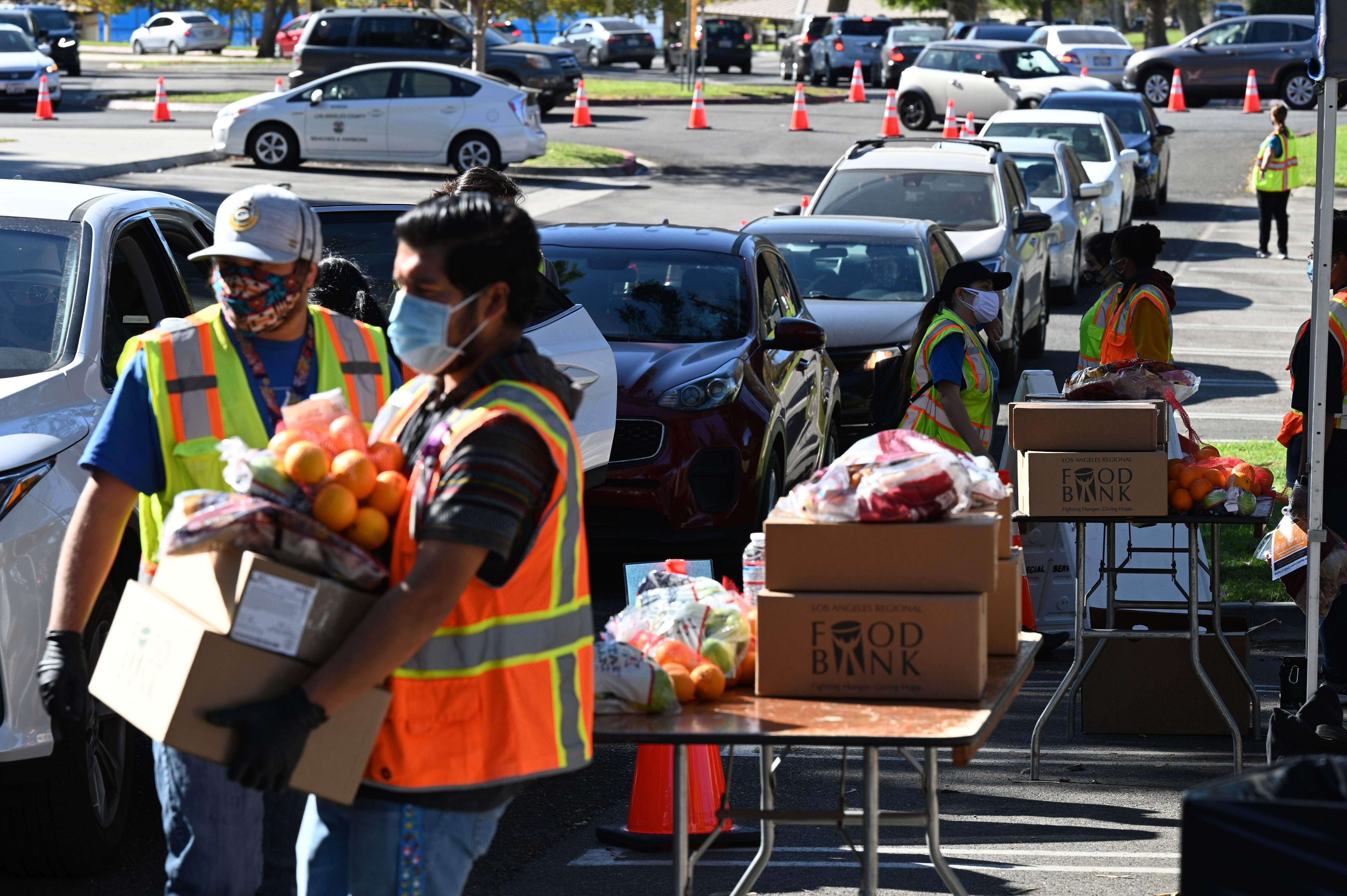 미국 캘리포니아주 로스앤젤레스(LA)에서 1일(현지시간) 푸드뱅크 자원봉사자들이 신종 코로나바이러스 감염증(코로나19) 사태로 먹거리 조달이 불안정해진 주민들의 차량에 무료 식료품을 실어주고 있다. AFP 연합뉴스