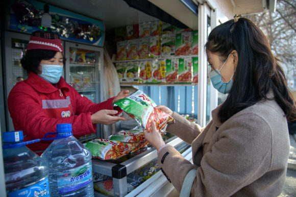 지난 1일 한 평양시민이 시내의 상점에서 류경김치공장에서 생산한 포장김치를 구입하고 있다. AFP 연합뉴스