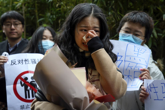 중국 미투 운동의 앞날을 가를 것으로 기대를 모으는 성희롱 재판이 시작된 2일 베이징 법원 앞에서 원고인 저우샤오솬이 자신을 지지하는 이들이 응원의 박수를 보내자 감격해 눈물을 흘리고 있다. 베이징 AP 연합뉴스 