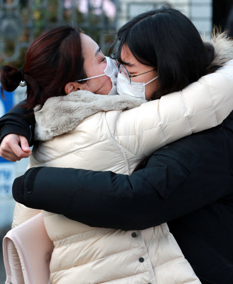 대학수학능력시험일인 3일 오전 부산 연제구 이사벨고등학교에서 한 학부모가 수험생 딸과 포옹하고 있다. 2020.12.3  연합뉴스