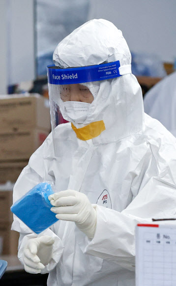 3일 오전 서울 송파구보건소 선별진료소에서 의료진이 감염을 막기 위해 방호복 틈에 테이프를 붙인 채 업무를 보고 있다. 2020.12.3  연합뉴스