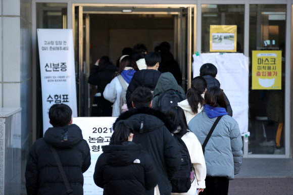 발열 체크 대기하며 논술 고사장 향하는 수험생들