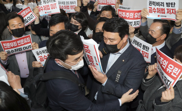 7일 오후 국민의힘 의원들이 더불어민주당의 고위공직자범죄수사처(공수처)법 개정안 등 입법 강행에 맞서 국회 법사위 회의실 앞에 집결해 규탄 구호를 외치는 가운데 민주당 김남국 의원이 국민의힘 의원들 사이를 뚫고 회의장으로 들어가고 있다.2020. 12. 7  김명국 선임기자 daunso@seoul.co.kr