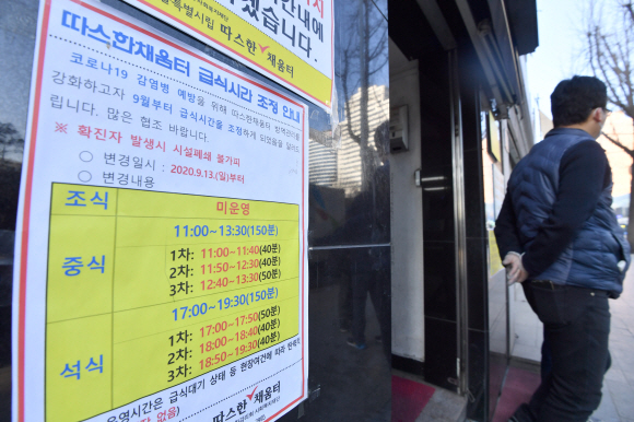 8일 용산구 서울역 인근 무료급식소에 코로나19 예방을 위해 운용시간을 분리한다는 안내문구가 적혀 있다. 2020.12.8 박지환기자 popocar@seoul.co.kr