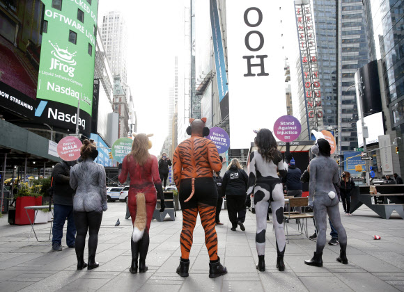 동물로 바디페인팅을 한 PETA 시위자들이 8일(현지시간) 미국 뉴욕 타임스퀘어에서 팻말을 들고 모여있다. UPI 연합뉴스