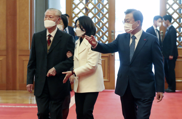 문재인 대통령이 세한도 기증자 손창근 옹을 청와대로 초청해 세한도(복제품)를 배경으로 기념사진을 촬영하기 위해 이동하고 있다. 손 옹 오른쪽은 며느리 고두연 씨. 2020. 12. 9 도준석 기자pado@seoul.co.kr