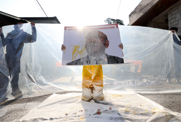 12·12 군사반란일을 맞아 5·18민주화운동서울기념사업회와 광화문촛불연대 등 시민단체 회원들이 12일 오후 서울 서대문구 연희동 전두환 전 대통령 자택 인근에서 처벌을 촉구하는 기자회견을 한 뒤 전 전 대통령 사진에 계란과 밀가루를 뿌리는 퍼포먼스를 하고 있다. 2020.12.12  연합뉴스