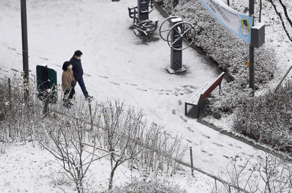 서울에 폭설이 내린 13일 반포의 한 아파트공원에서 시민들이 눈이 쌓인 거리를 걷고 있다.  2020.12.13 박지환 기자 popocar@seoul.co.kr