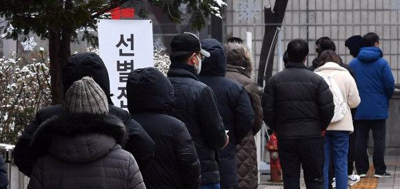 확진자가 1000명을 돌파한 13일 서울 서초구 보건소에서 코로나 19 검사를 받기 위해 시민들이 줄을 서 있다. 2020.12.13 박지환기자 popocar@seoul.co.kr