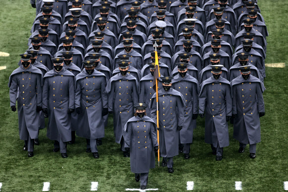 육군 생도들이 12일(현지시간) 미국 뉴욕주 웨스트포인트에서 열린 해군과의 NCAA 대학 축구 경기 전에 경기장에서 행진하고 있다. AP 연합뉴스