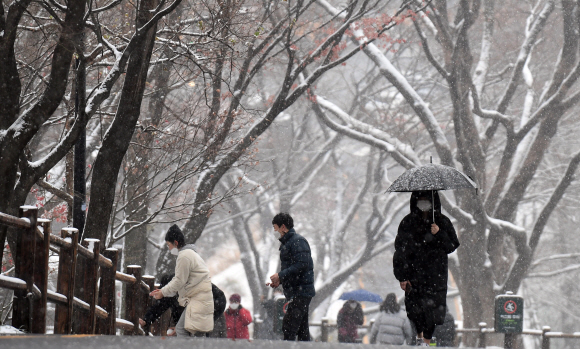 올겨울 첫 대설주의보가 내려진 13일 서울 남산을 찾은 시민들이 눈길을 걷고 있다. 2020. 12. 13 박윤슬 기자 seul@seoul.co.kr