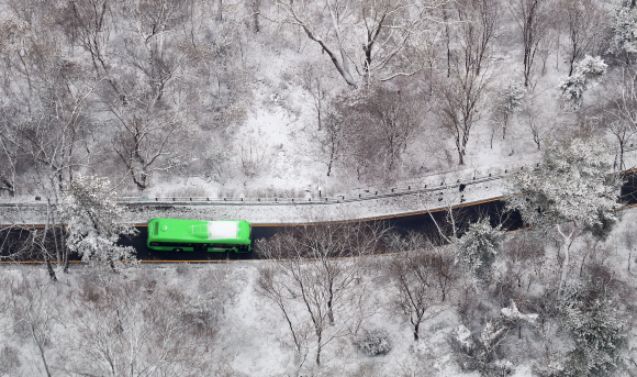 올겨울 첫 대설주의보가 내려진 13일 서울 남산에서 버스가 내려가고 있다. 2020. 12. 13 박윤슬 기자 seul@seoul.co.kr