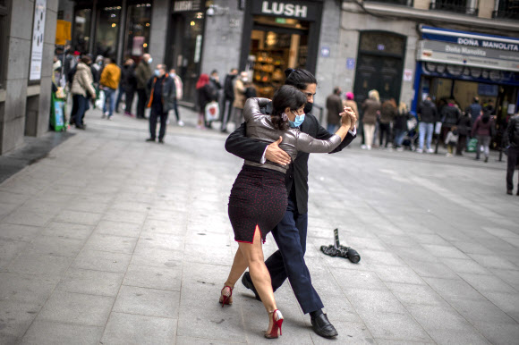 코로나 19 확산을 막기 위해 얼굴 마스크를 쓴 거리 댄서들이 16일(현지시간) 스페인 마드리드 시내에서 탱고 춤을 추고 있다.  AP 연합뉴스