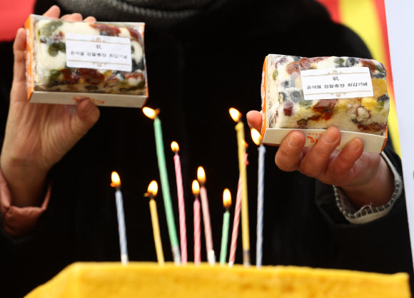 18일 오전 서울 서초구 대검찰청 앞에서 윤석열 검찰총장 지지자들이 윤 총장의 환갑을 맞아 축하 떡을 들고 노래를 부르고 있다. 2020.12.18  연합뉴스