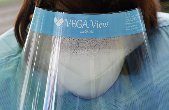 코로나 19 확진자가 계속해서 늘어나는 20일 서울역 광장에 설치된 중구 임시 선별검사소에서 의료진의 안면 마스크에 추위로 인해 습기가 차 있다. 2020.12.20  오장환 기자 5zzang@seoul.co.kr