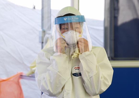 코로나 19 확진자가 계속해서 늘어나는 20일 서울역 광장에 설치된 중구 임시 선별검사소에서 의료진이 안전 장비를 착용하고 있다. 2020.12.20  오장환 기자 5zzang@seoul.co.kr