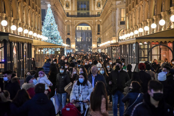 지난해 연말 크리스마스 장식으로 화려하게 꾸며진 이탈리아 밀라노 시내 중심가에서 시민들이 거리두기를 전혀 하지 않은 채 쇼핑을 하고 있다. 밀라노 EPA 연합뉴스
